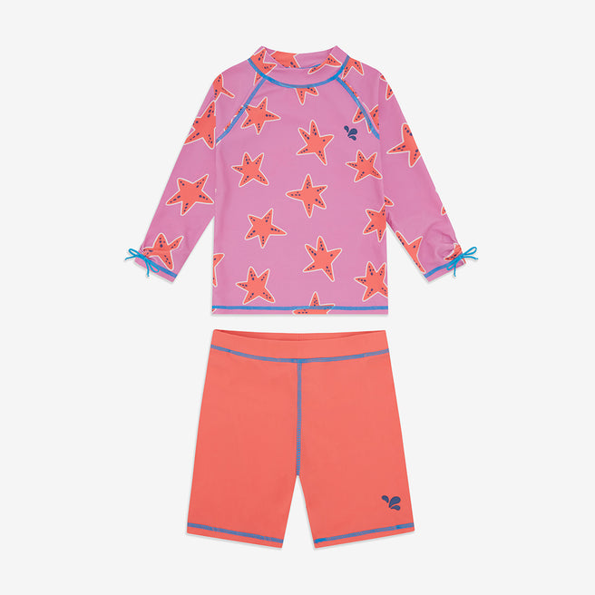 UV Protective Surf Set Pink Starfish, a child's long-sleeved rash guard top with starfish print and coral swim shorts with blue trim.